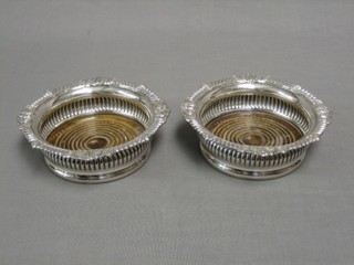 A pair of circular silver plated wine coasters with embossed bodies 7"