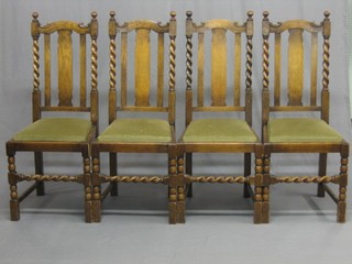 A set of 4 1930's oak stick and bar back dining chairs with spiral turned column decoration and upholstered drop in seats, raised on turned and block supports