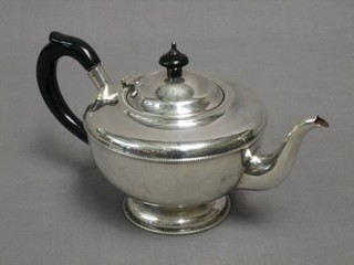 A circular silver teapot with bead work border, raised on a circular spreading foot, Birmingham 1933 12 ozs