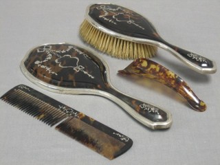 A tortoiseshell and silver backed hairbrush, London 1910, a matching silver hand mirror, 1911, a tortoiseshell comb and a shoe horn