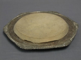 A circular wooden bread board contained in a silver plated frame