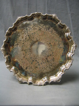 An engraved circular silver plated salver with bracketed border raised on scroll feet 14"