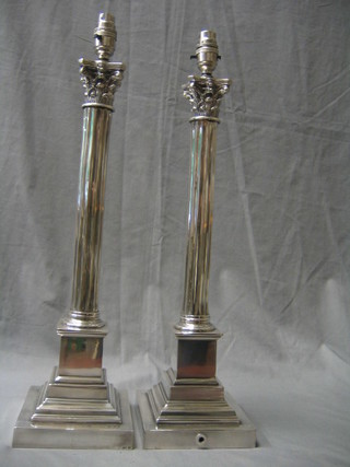 A pair of silver plated reeded column table lamps with Corinthian capitals