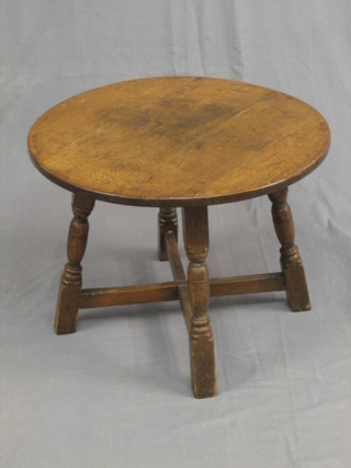 A circular oak occasional table raised on turned and block supports 24"