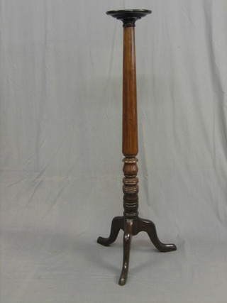 A turned mahogany torchere raised on pillar and tripod supports