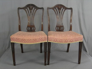 A set of 6 19th/20th Century Hepplewhite style dining chairs with pierced vase splat backs and upholstered drop in seats, raised on square tapering supports ending in spade feet