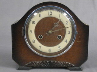 A 1950's 8 day striking mantel clock with silvered dial and Arabic  numerals contained in an oak arch shaped case