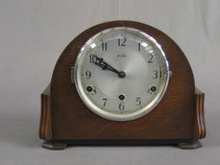 A 1930's 8 day Westminster chiming mantel clock with silvered dial and Arabic numerals contained in an oak arch shaped case