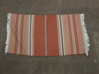 A machine made orange ground and striped rug 49" x 30"