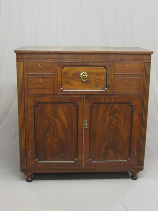 A Regency mahogany D shaped secretaire chest, with well fitted secretaire drawer with secret drawer above, flanked by 2 short drawers, the base fitted a cupboard with trays enclosed by panelled doors flanked by reeded columns 44"