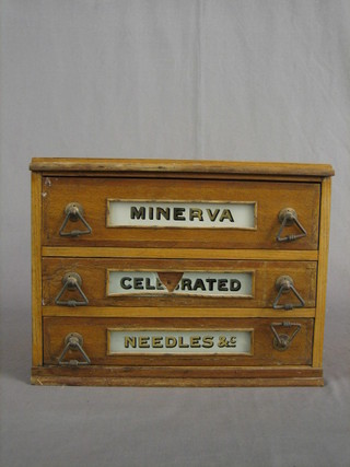 A draper's oak 3 drawer cabinet marked Minerva Needles etc 14"