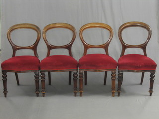 A set of 5 Victorian mahogany spoon back dining chairs with carved shaped mid rails and upholstered seats, raised on turned supports