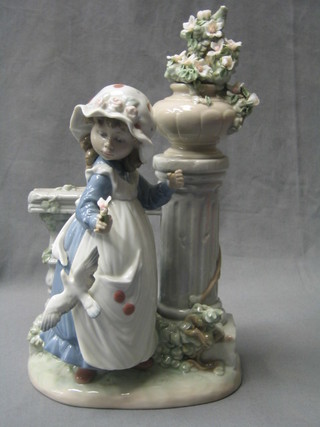 A Lladro figure of a standing bonnetted girl by a balustrade with urn and dove, the base marked Lladro D31 O, 11"