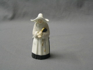 A Royal Worcester candle snuffer in the form of a nun, the base with black Worcester mark
