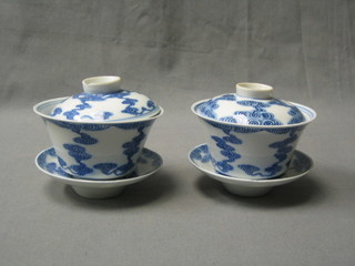A pair of 18th/19th Century Oriental blue and white porcelain rice bowls and covers complete with saucers, the base and lids with 6 character mark, (Kuang-Hsi period?) (1 lid slightly chipped)