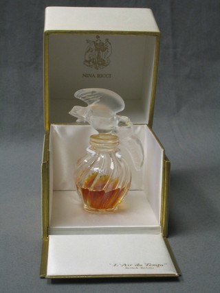 A bottle of Nina Ricci perfume contained in a Lalique glass bottle depicting 2 doves in flight, the base marked Nina Ricci France, bottle made by Lalique complete with original cardboard carton