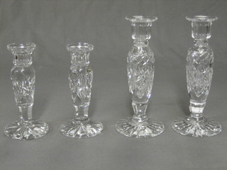 A pair of cut glass candlesticks, raised on circular bases 8" (1 with chip to rim) and 2 other cut glass candlesticks (1 with chip to rim)