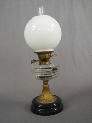 A 19th Century glass oil lamp reservoir raised on a gilt metal base with opaque glass shade and chimney