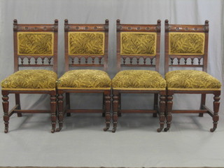 A set of 4 Edwardian carved walnut dining chairs with upholstered seats and backs, raised on turned and fluted supports with H framed stretcher