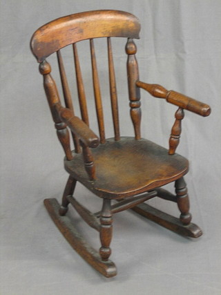 A childs 19th Century elm stick and bar back rocking chair (old worm to seat)