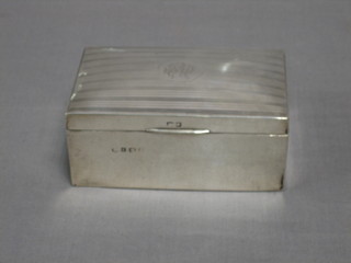 A silver cigarette box with engine turned decoration and hinged lid, 5 1/2"