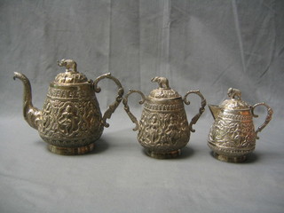 An Indian embossed silver 3 piece tea service, the bodies cast deities, the finials in the form of elephants comprising teapot, twin handled sugar bowl and cream jug 38 ozs