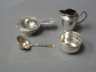A Continental silver tea strainer and stand, a do. sifter spoon and a silver plated cream jug and sugar bowl