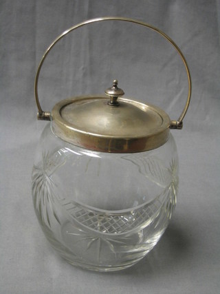 A circular cut glass biscuit barrel with silver plated mounts