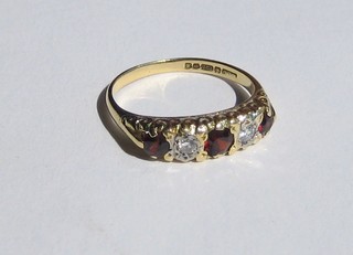 A lady's 18ct gold dress ring set a garnet and diamonds