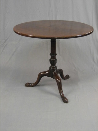 A 19th Century circular mahogany tea table raised on a gun barrel turned column and tripod supports 31"