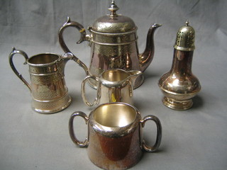 A Victorian silver plated teapot with engraved decoration, a matching cream jug, a hotelware twin handled sugar bowl and cream jug and a sugar castor