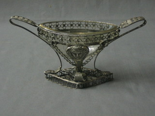 A curious Eastern pierced filigree boat shaped twin handled dish frame with clear glass dish 9"