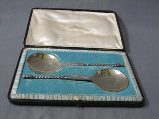 A pair of Edwardian silver plated serving spoons, cased