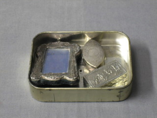 A miniature easel silver photograph frame 3", an oval silver pill box 1 1/2" and a Continental silver pill box with embossed lid 1 1/2"