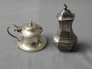 A circular silver capstan shaped mustard pot Sheffield 1924 and a silver pepper pot Birmingham 1933