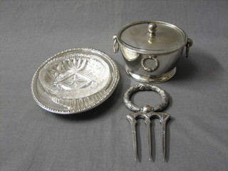 A silver plated bread fork, a circular silver plated butter dish with cut glass liner and a silver plated dessert jar and cover