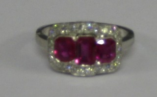 A lady's 18ct white gold dress ring set 3 large rectangular cut rubies supported by numerous diamonds