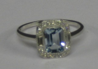 A lady's 18ct white gold dress ring set a rectangular cut aquamarine and 2 baguette diamonds and numerous other diamonds