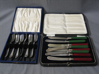 A set of 6 silver plated pastry forks cased and a set of 8 tea knives, cased