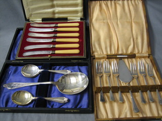 A silver plated serving spoon and 4 do. fruit spoons cased, a set of 6 silver plated pastry forks and servers, cased and a set of 6 silver plated tea knives cased