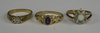 A lady's gold dress ring set an oval cut amethyst and 2 other gold dress rings