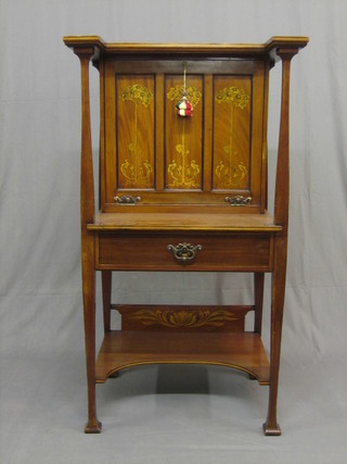 An Edwardian Art Nouveau inlaid mahogany student's bureau, the fall front inlaid stylised trees, the interior fitted various cupboards, pigeon holes, drawers etc, the base fitted 1 long drawer, raised on square tapering supports with undertier 28" (2 old repairs to back legs)