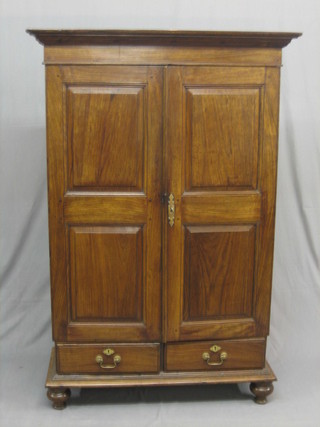 An Oriental hardwood cabinet, the interior fitted shelves enclosed by panelled doors, the base fitted 2 drawers  on bun feet 40"