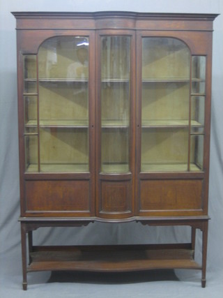 An Edwardian inlaid mahogany display cabinet with moulded cornice, the shelved interior enclosed by glazed panelled doors, raised on square tapering supports ending in spade feet and  with undertier, 48"