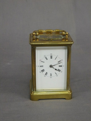 A 19th Century French 8 day striking carriage clock with porcelain dial and Roman numerals contained in a gilt metal case