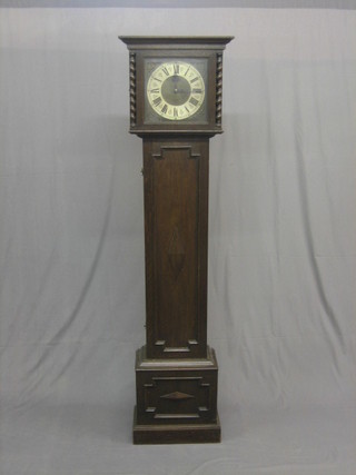 A 1930's chiming longcase clock the 10" brass dial with gilt metal spandrels and silvered chapter ring contained in a Jacobean style oak case 70"