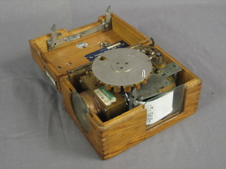 A racing pigeon clock by the Automatic Timing Company Ltd contained in an oak carrying case
