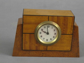 A 1930's bedroom timepiece contained in a square walnut case