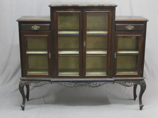 An Edwardian ebonised display cabinet fitted a cupboard enclosed by glazed panelled doors flanked by a pair of cupboards with drawer above, raised on carved cabriole supports 53"
