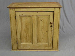 A 19th Century stripped and polished pine side cabinet enclosed by panelled door, raised on a platform base 36"